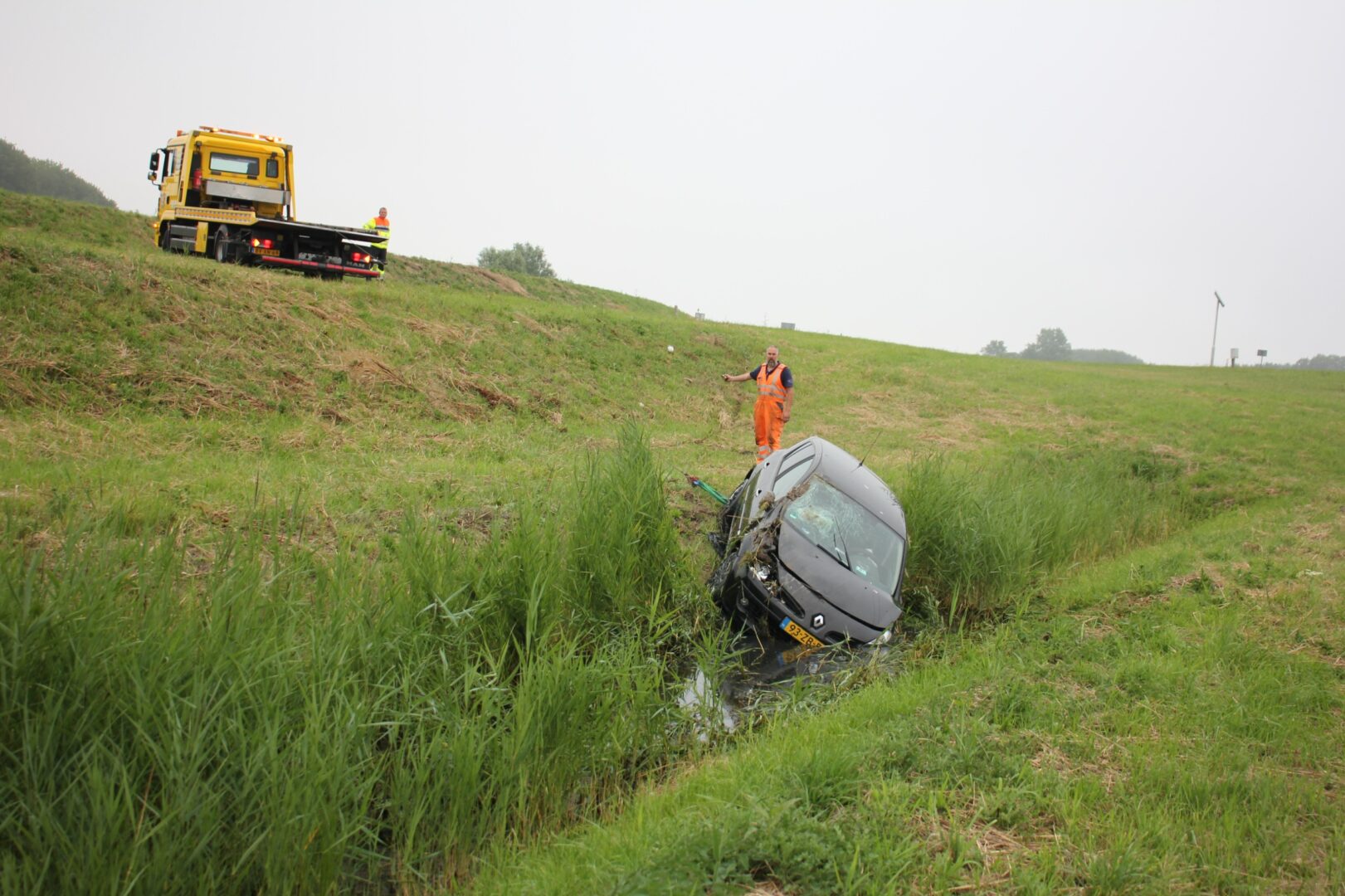 Auto in greppel naast afrit N31 Marsum