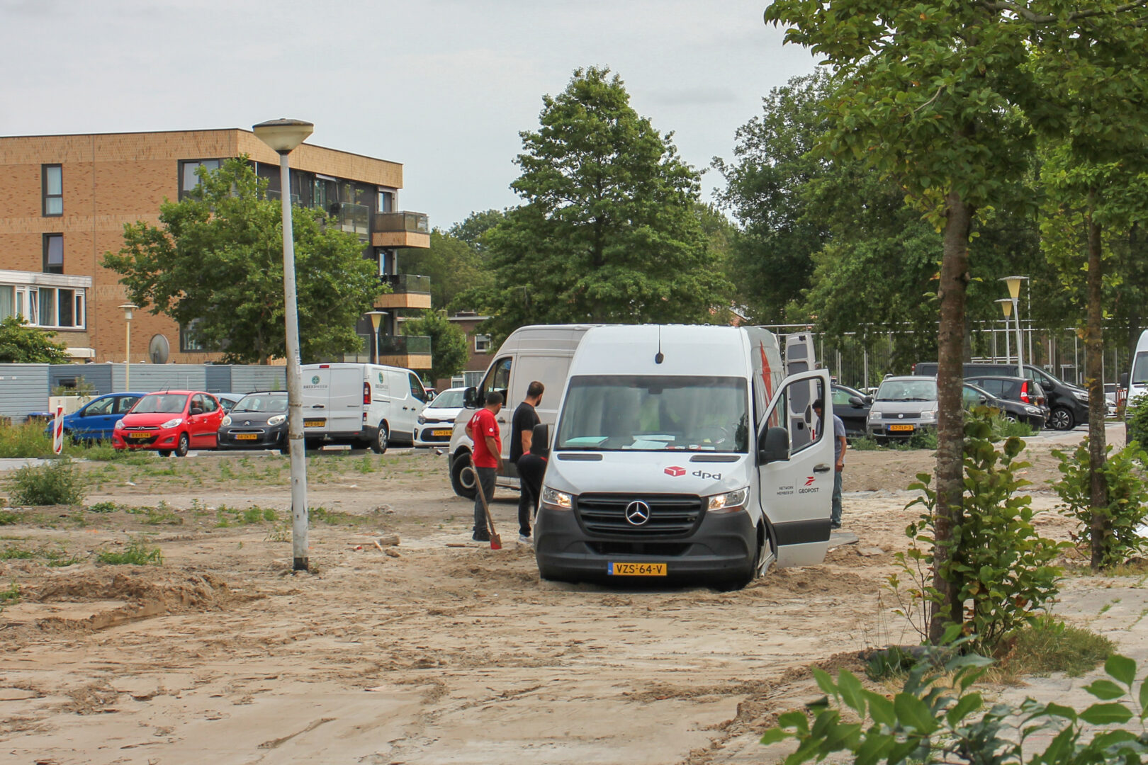 Pakketbezorger vast in zand in afgesloten