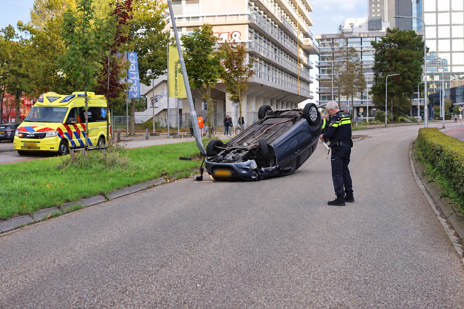 Auto over de kop na botsing met lantaarnpaal