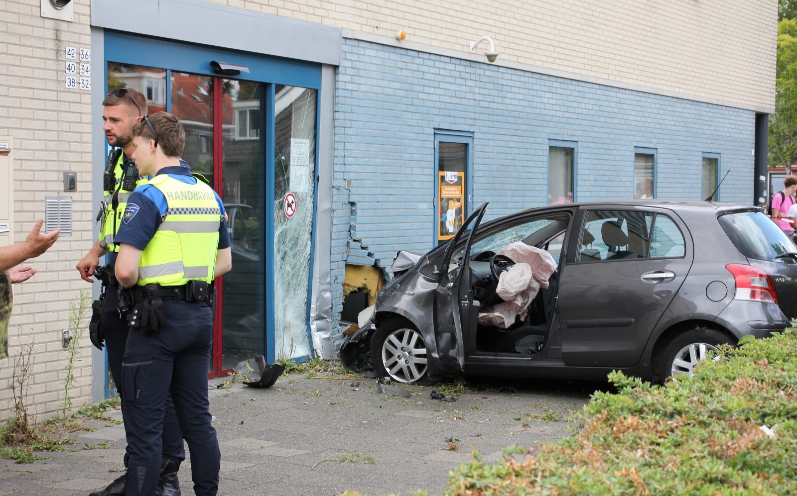Auto ramt lantaarnpaal en gevel; twee gewonden