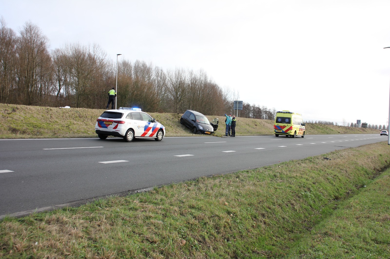Auto schiet over geluidswal