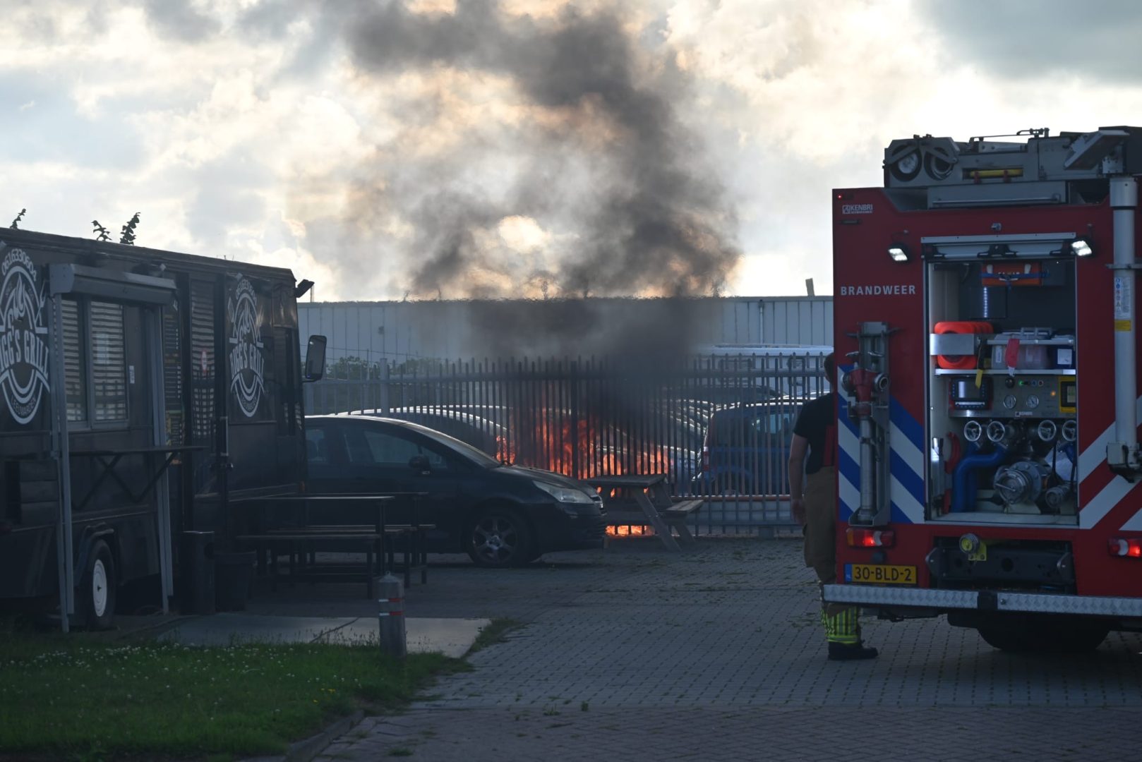 Auto in brand op opslagterrein